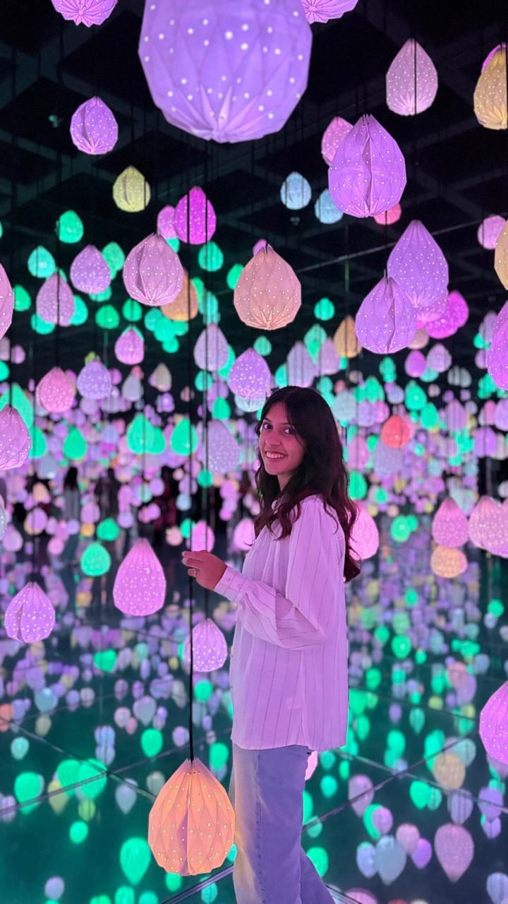 Treya in a room of glowing paper lights